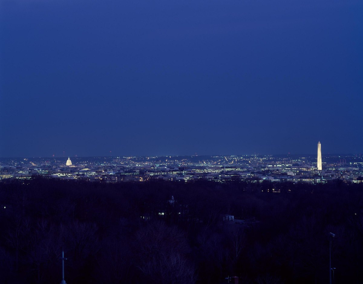 Washington at night, with the illuminated Capitol and Washington Monument on the horizon.